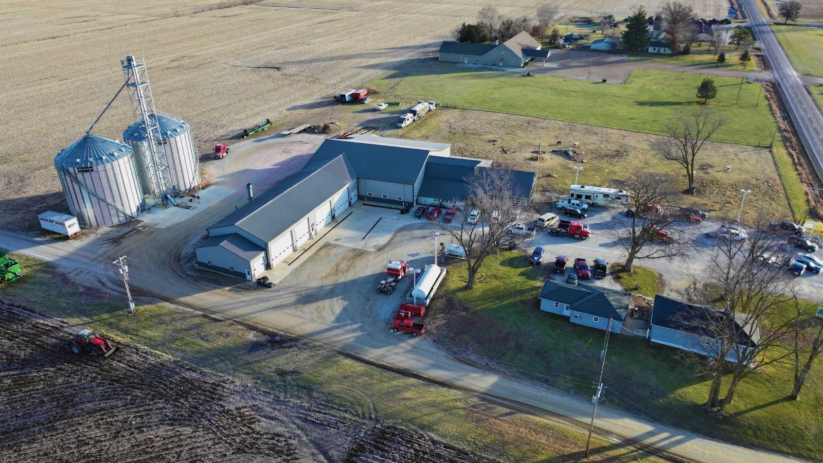 Aerial view of a farm shop, grain bins, and equipment yard