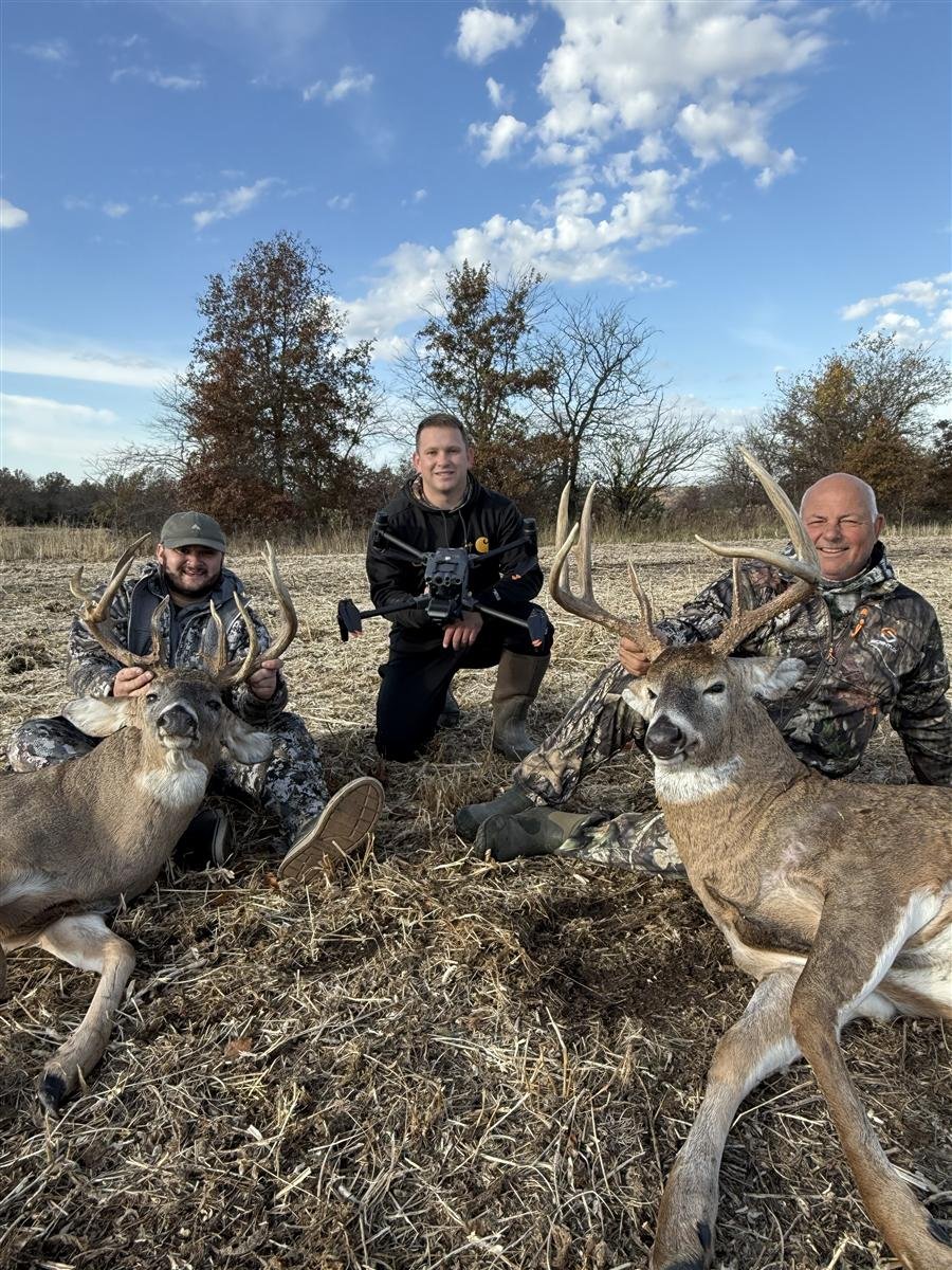 Three hunters with two recovered bucks and a Recon1 drone, daytime